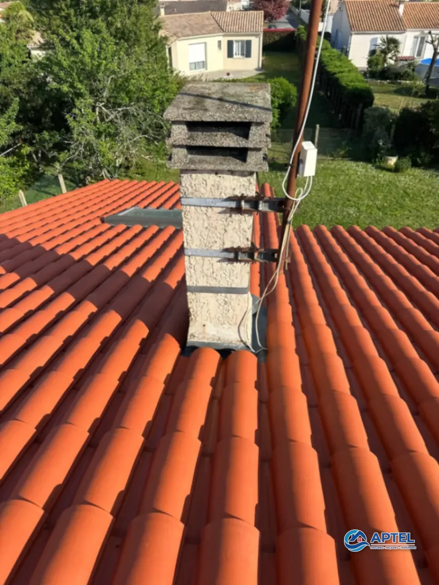 Toiture autour de cheminée propre après démoussage manuel par artisan à Saint-Agnant
